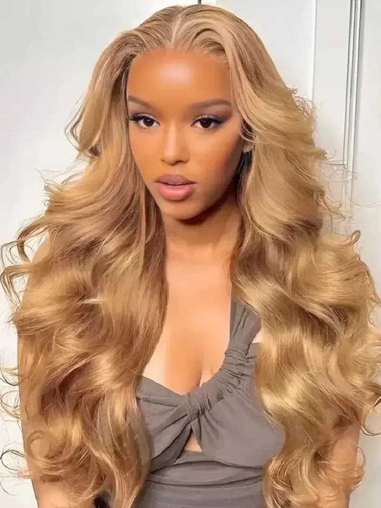 Honey blonde lace frontal wig with glam waves worn by a model with middle part