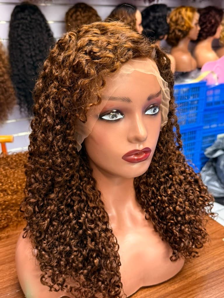 Pixie cut curly lace wig with auburn brown spiral curls and side part on a mannequin